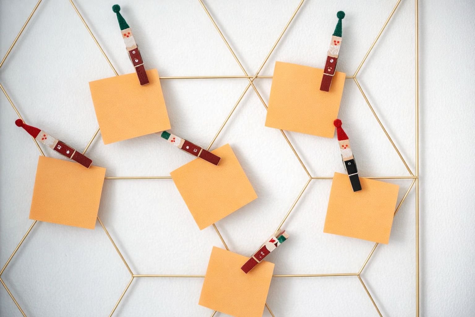 Gult metallnät med orangea lappar fästa med små jultomte-klämmor.