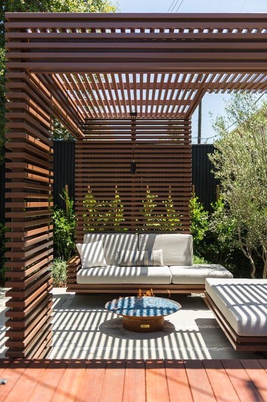 Träspaljé och pergola skapar ett avskärmat uterum med soffa